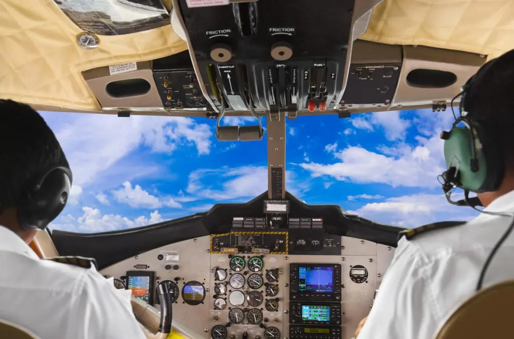 Cockpit view with pilots and blue sky.